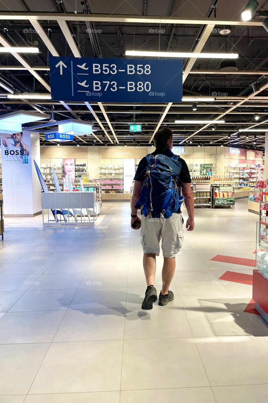 Man walking towards the shops in the airport 
