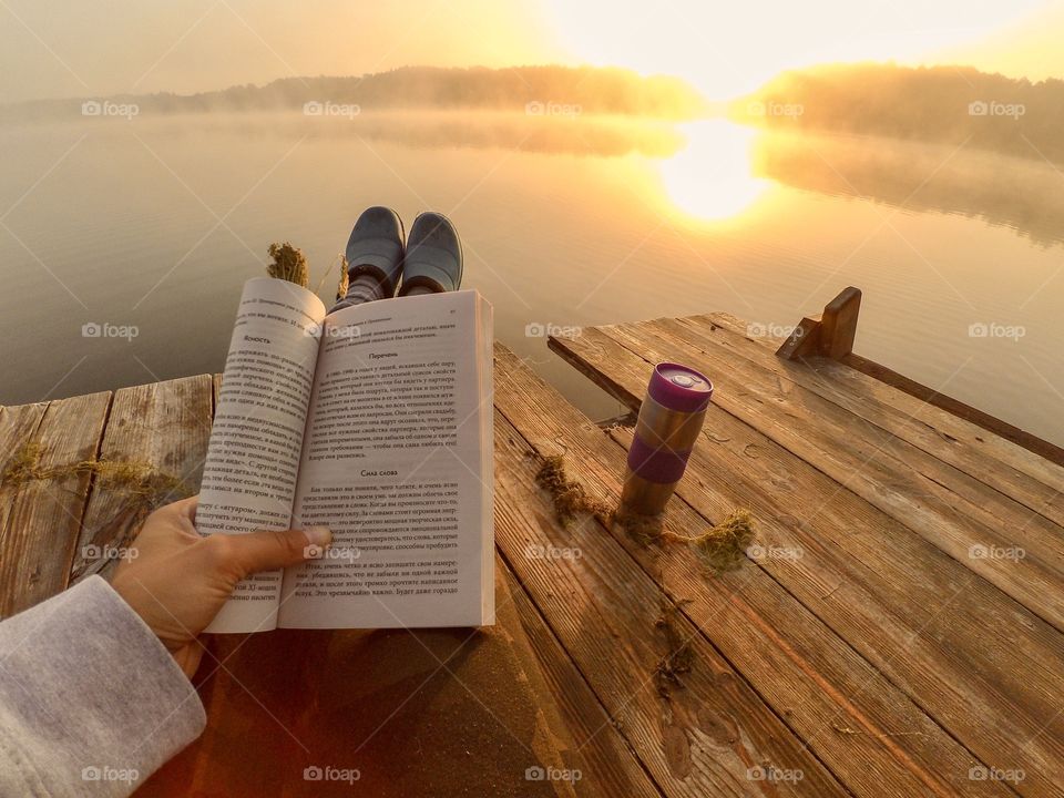Enjoying sunrise with coffee and book on the river. 