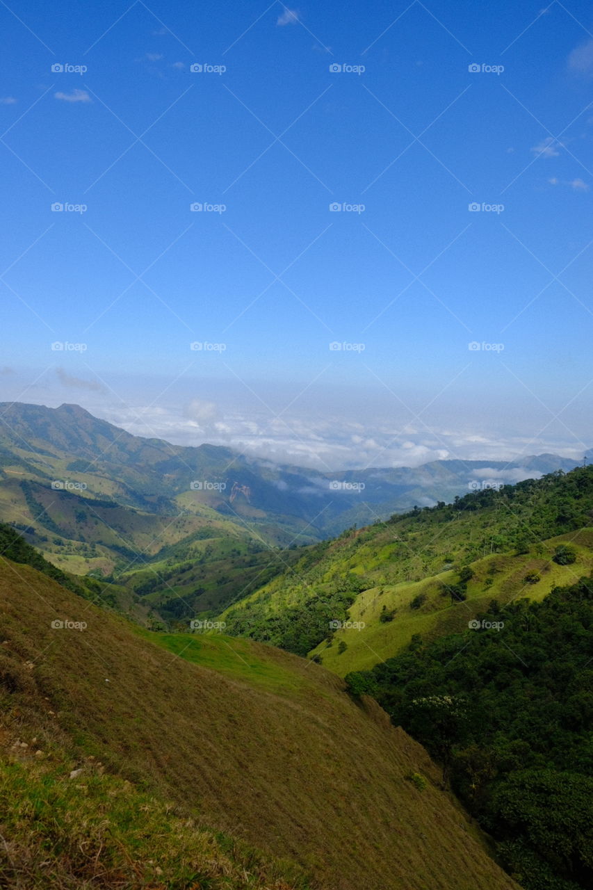 cielo azul con montañas con vegetación verde