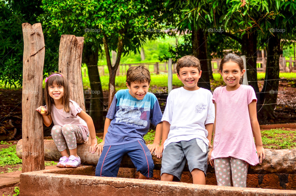 Happy friends sitting on wood in park