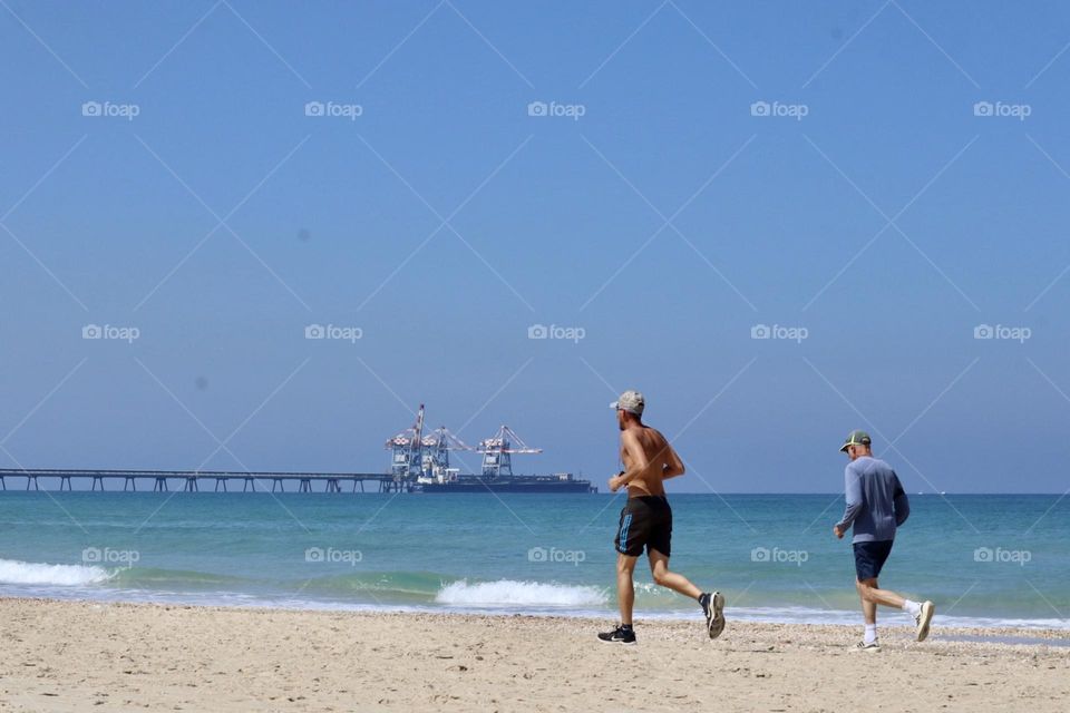 Men run on the beach