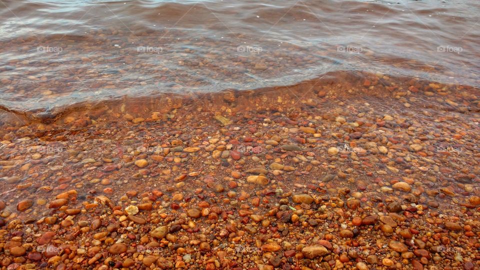 Pedras e águas. Margem de rio, praia.