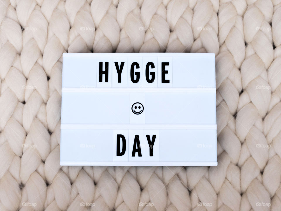 HYGGE DAY On A Light Box With Knit background. Holiday concept. Cozy compozition. Merino wool handmade knitted large blanket