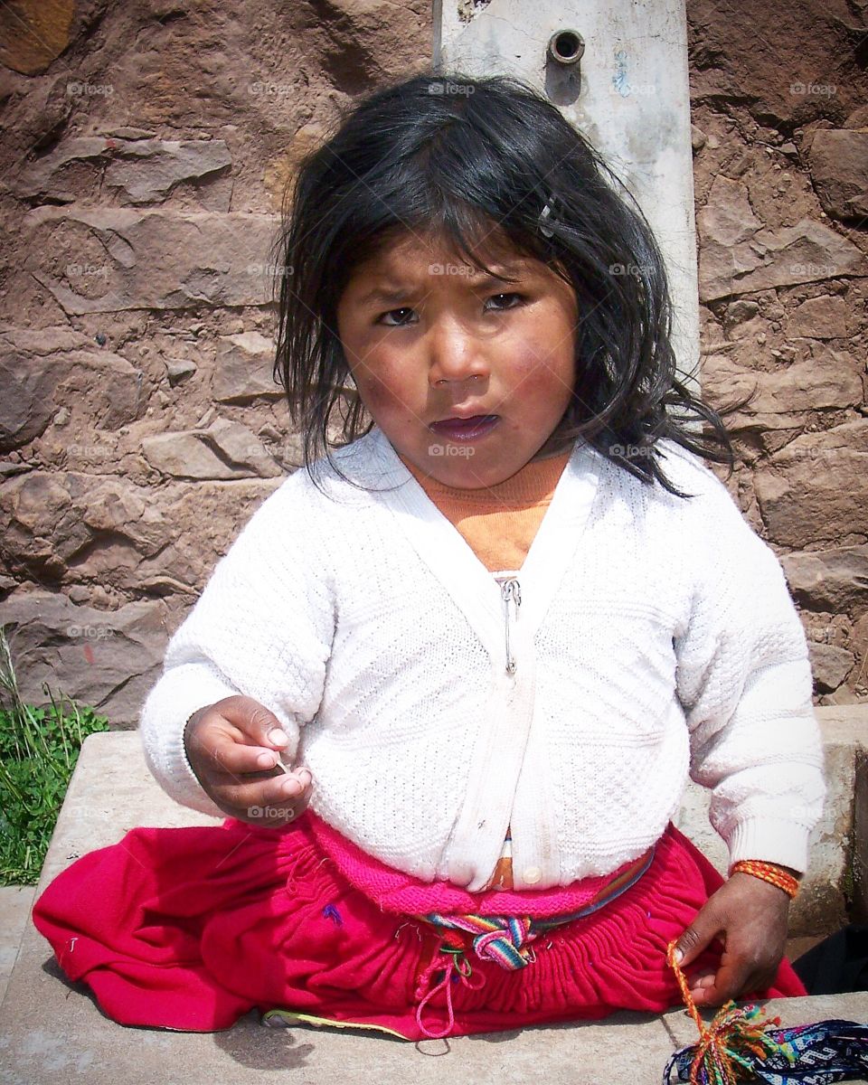 A child selling jewelry or asking for change from the tourists.