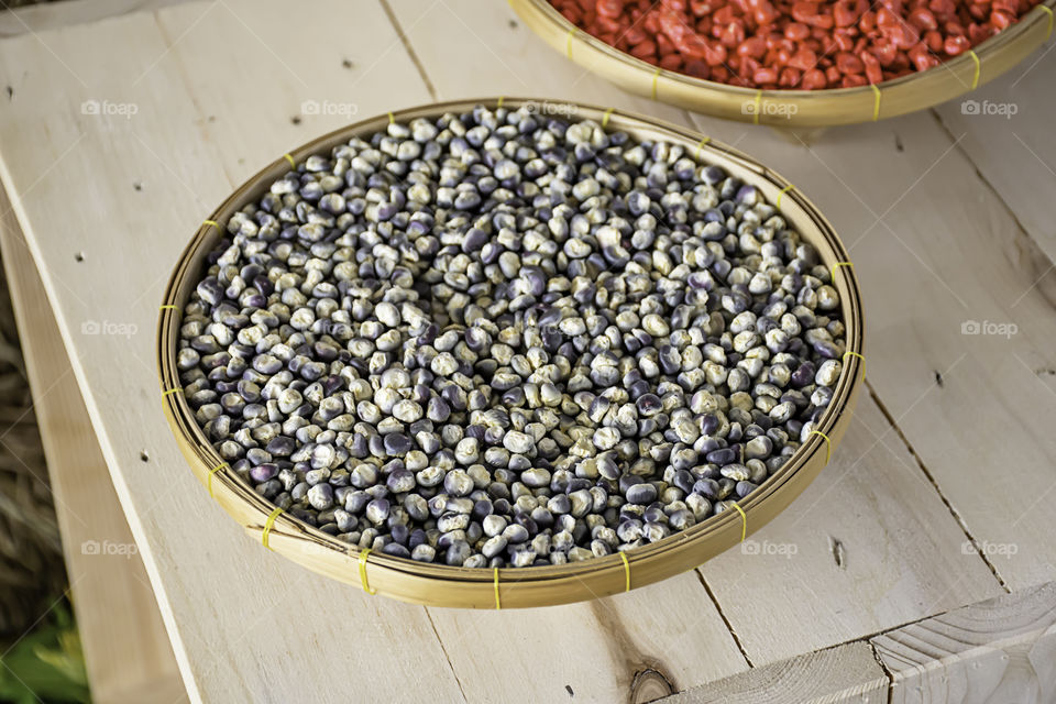 Seed corn in bamboo baskets on wooden table.