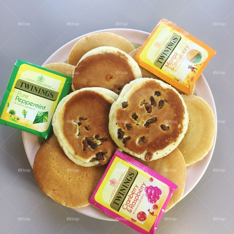 Colorful Tea and pancakes on a plate with plain background 