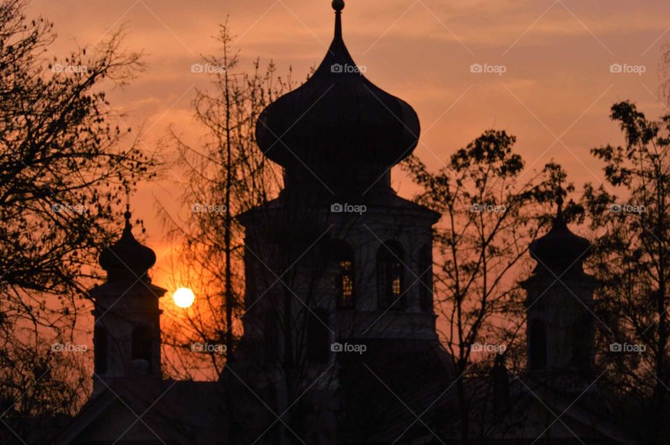 beautiful sunset in the city behind church