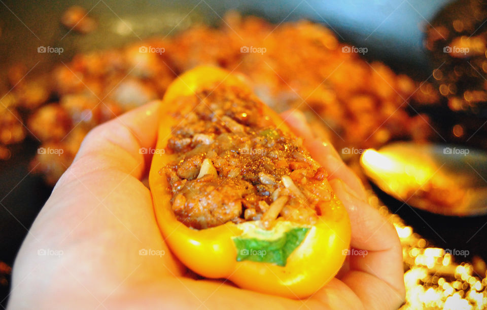 Cooking, stuffed mini bell peppers in hand
