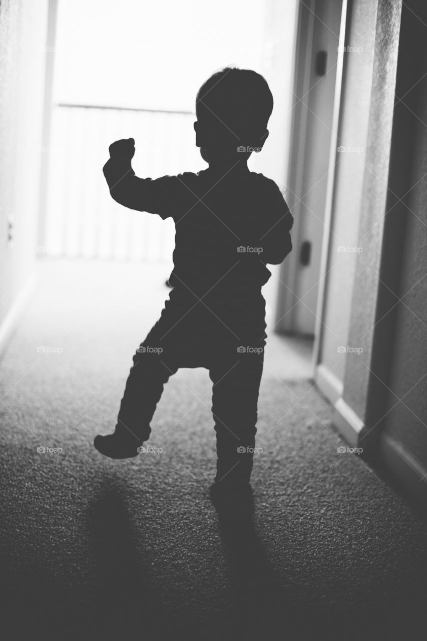 Silhouette of a toddler walking down the hallway