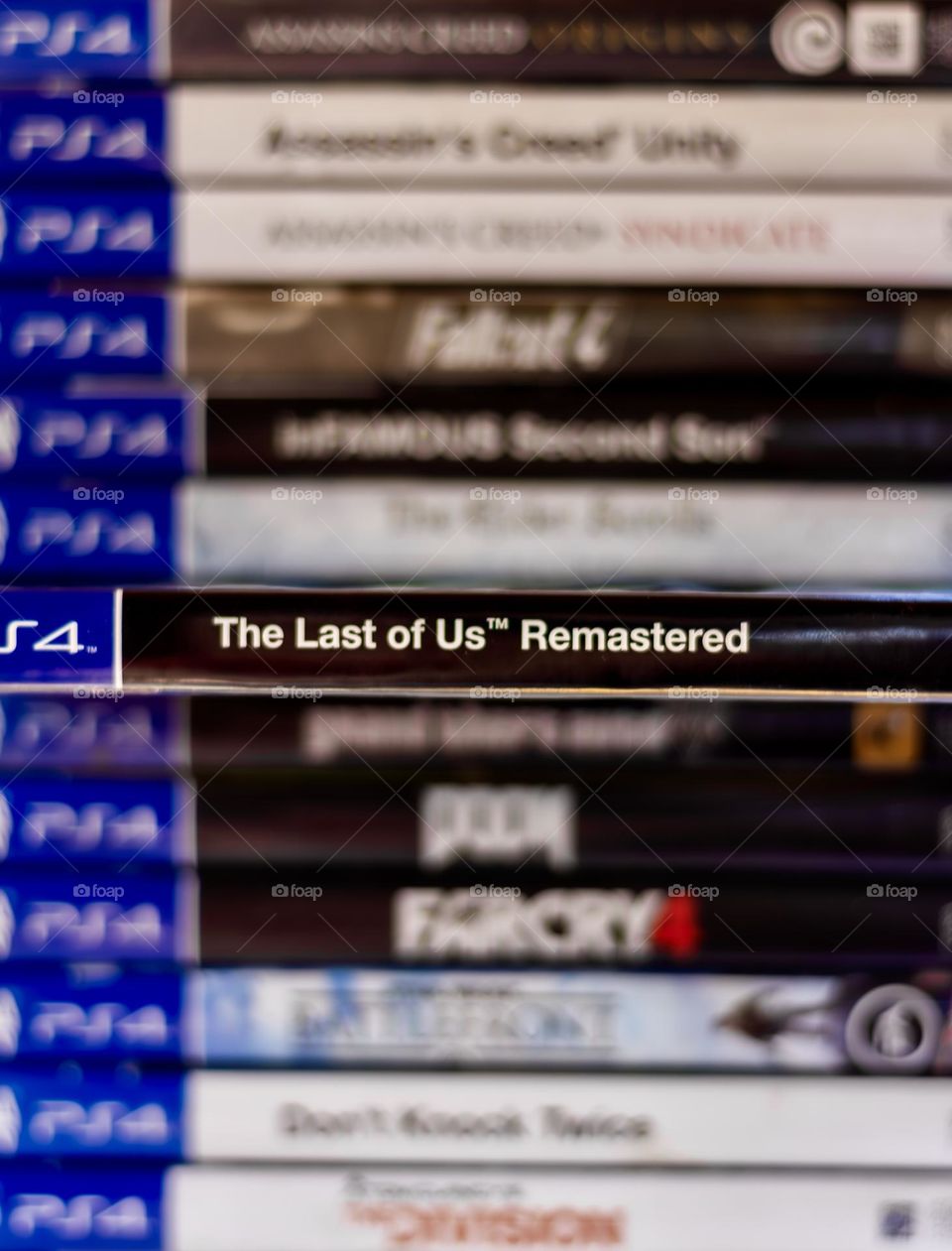 Stack of PS4 games with The Last of Us, pulled out from the pile