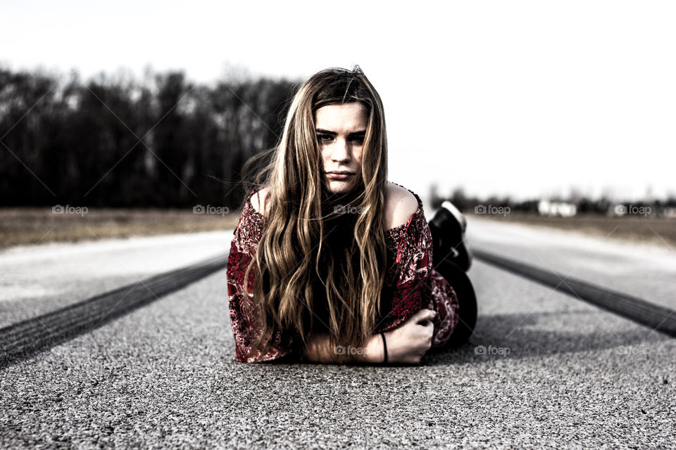 Woman with long hair lying on street