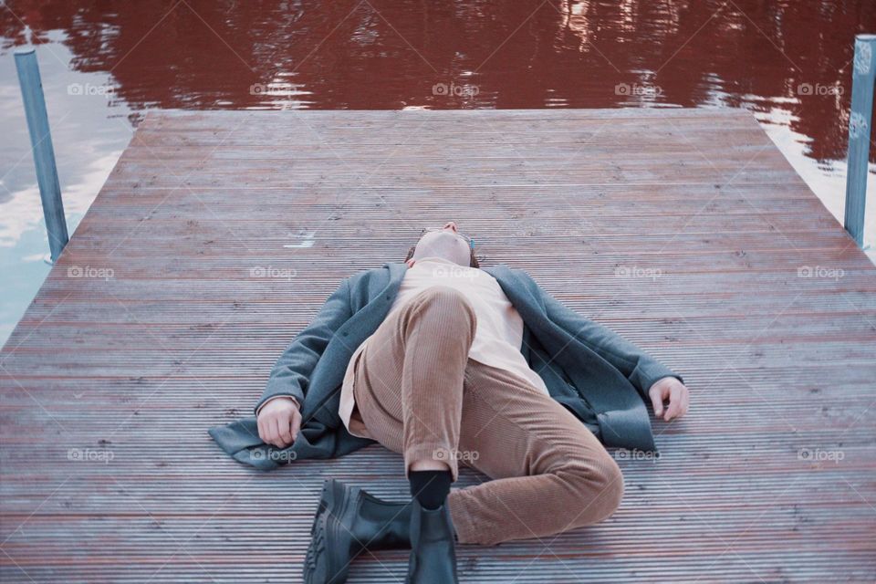 A man is lying on the bridge