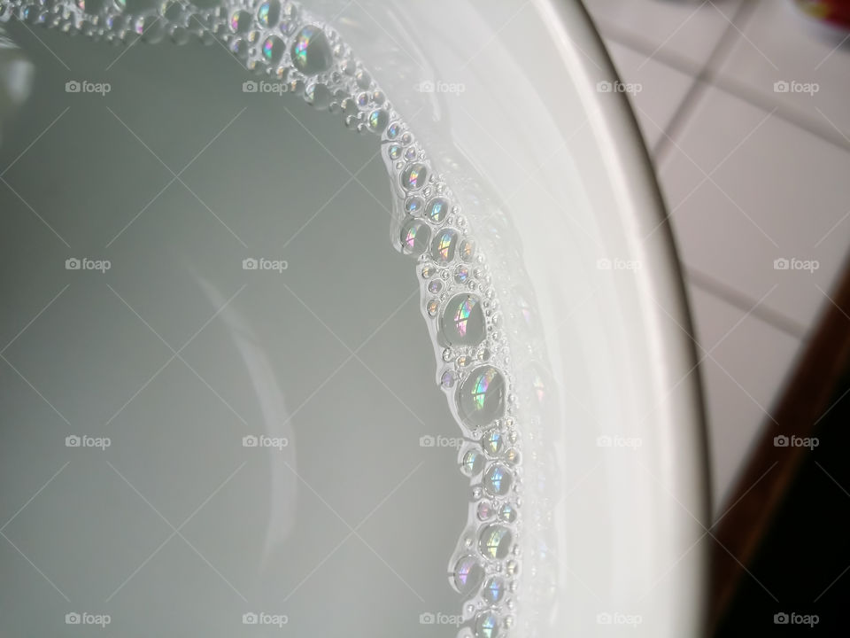 Tiny Soap Bubbles in a White Bowl of Water