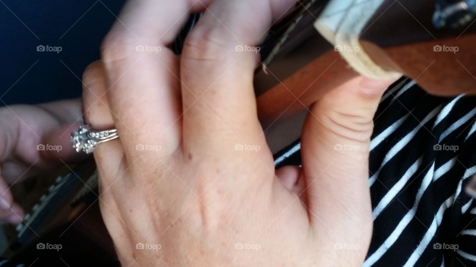 Young woman's hands playing guitar.