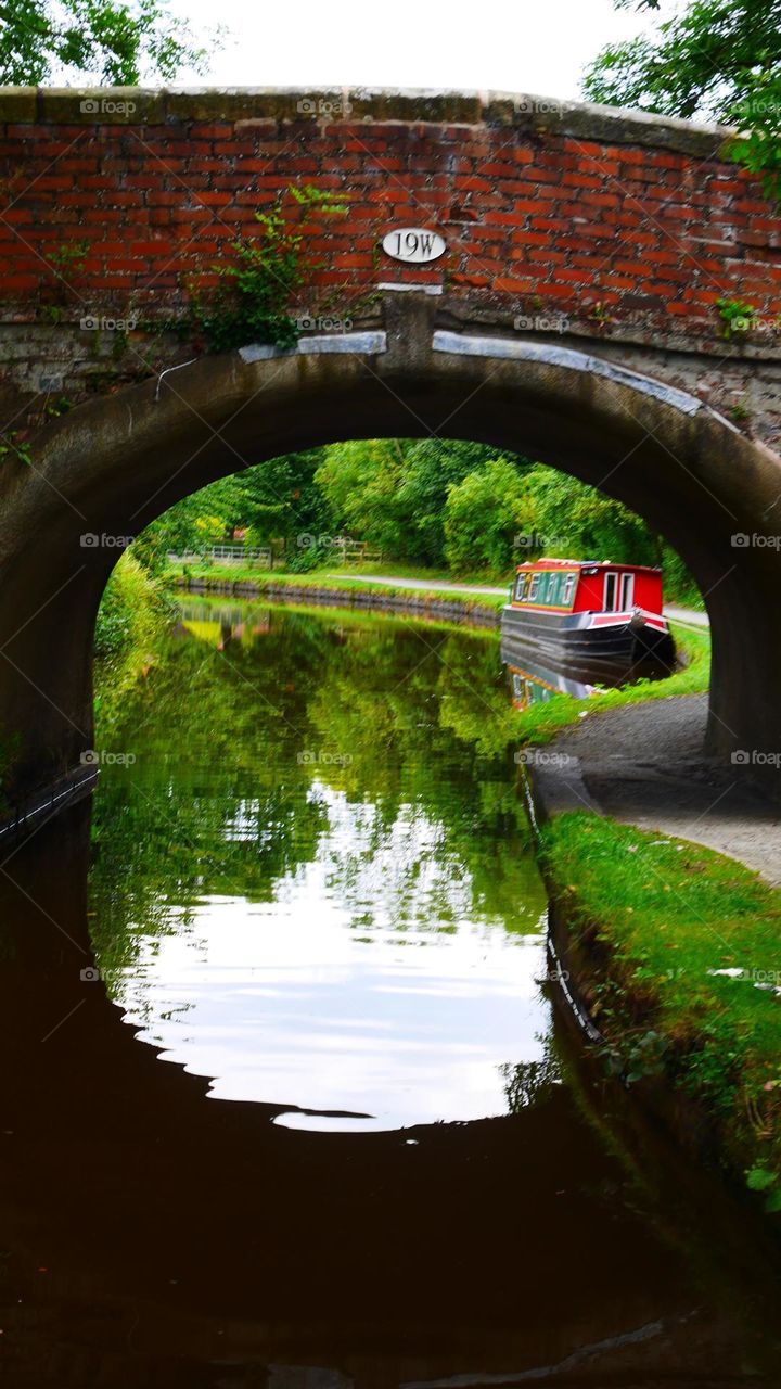 Longboat on canal waterways view under the bridge