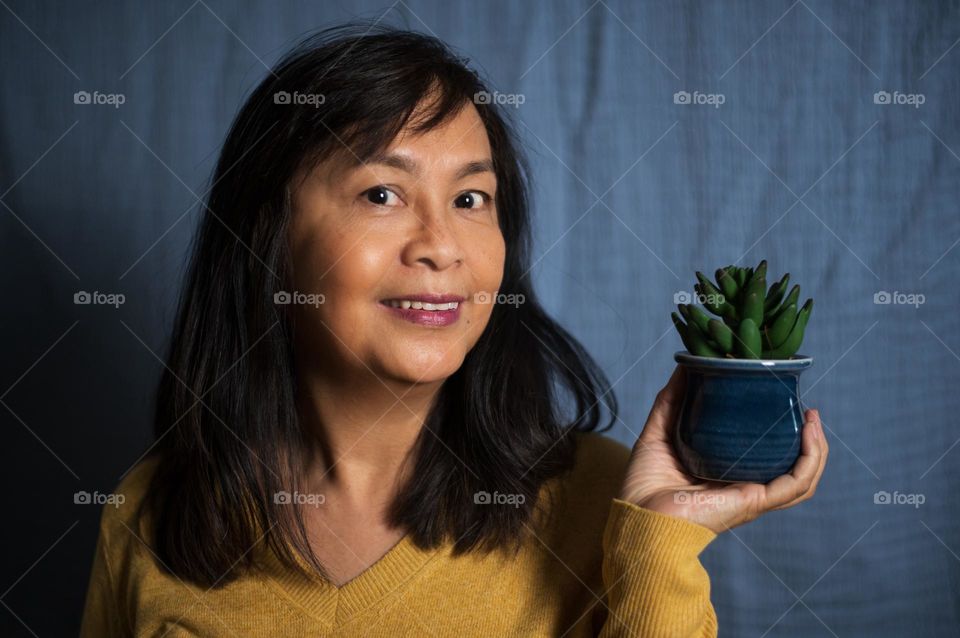 Portrait of a woman holding a plant 