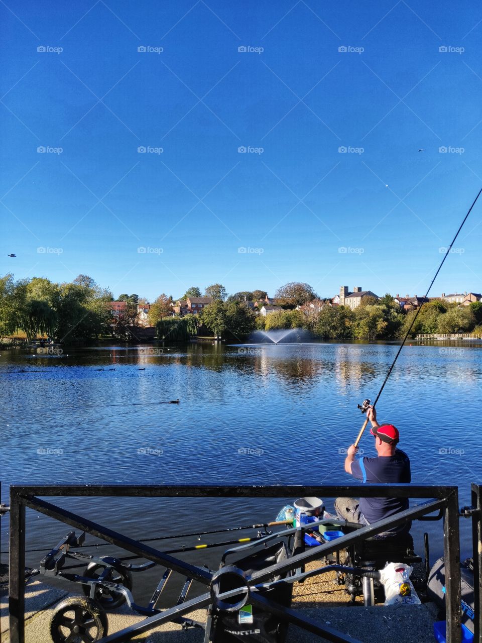 Man fishing in town mere