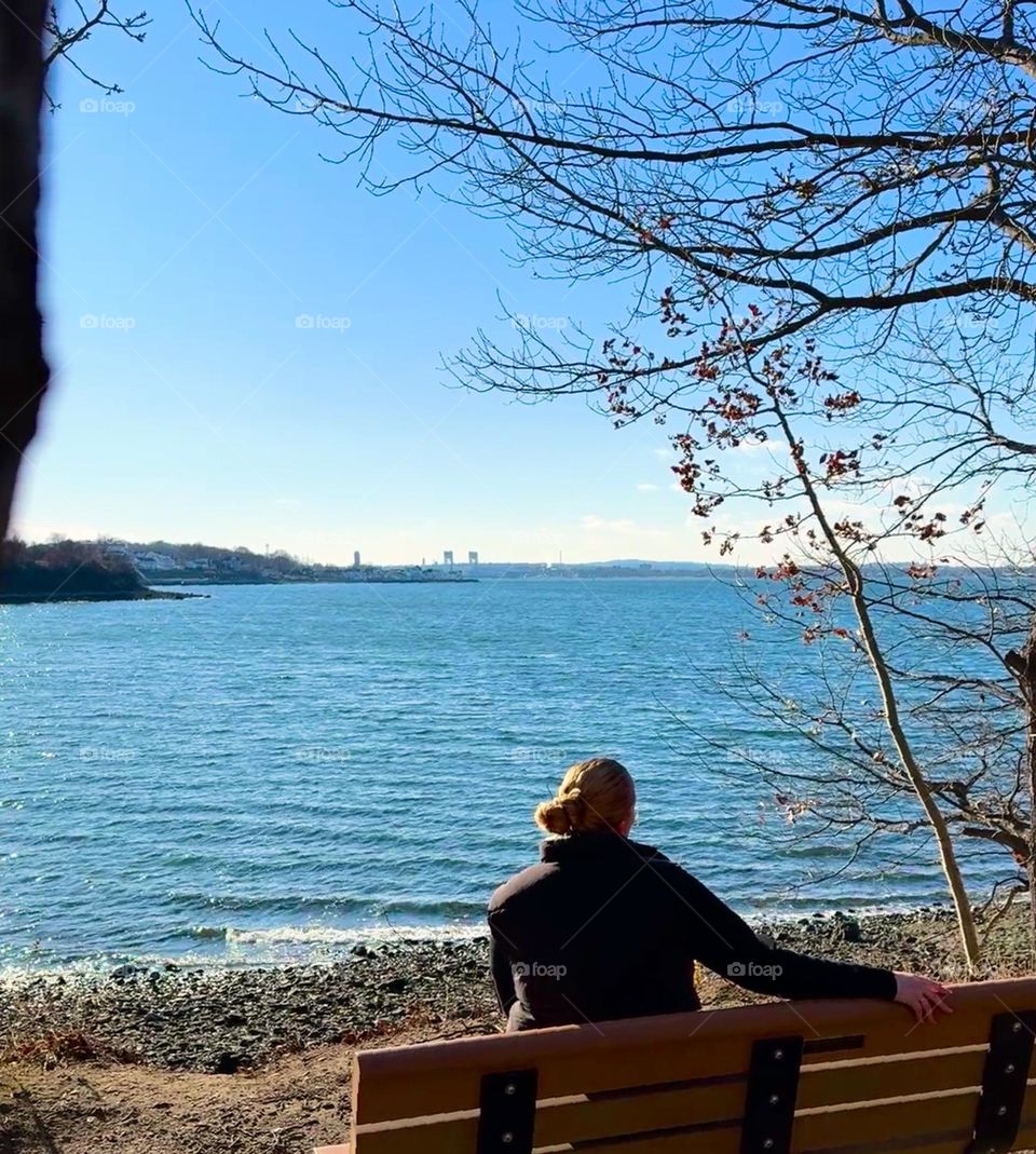 The girl looks at the city through the water