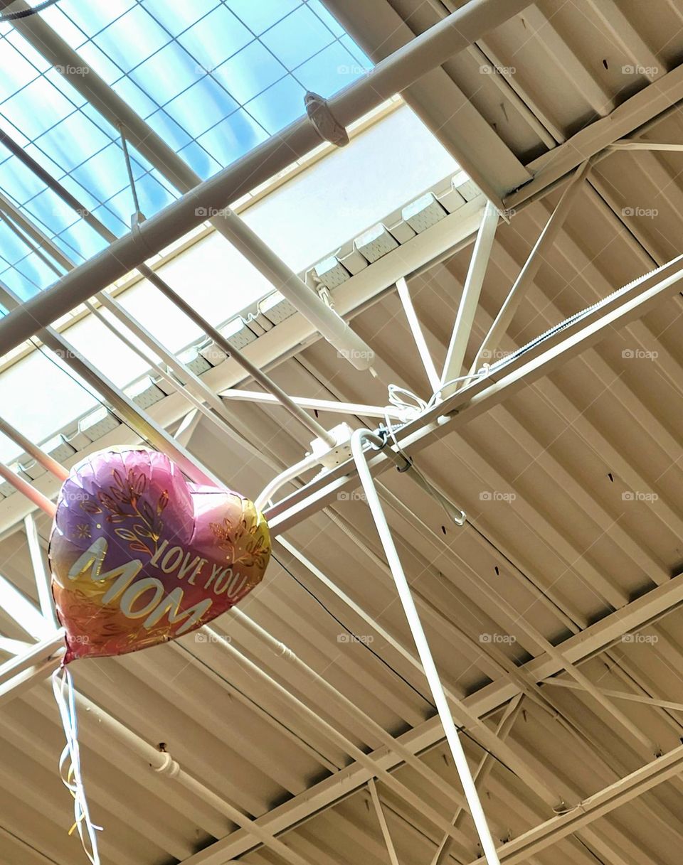 untethered mother's day themed helium balloon caught in the rafters of an Oregon grocery store