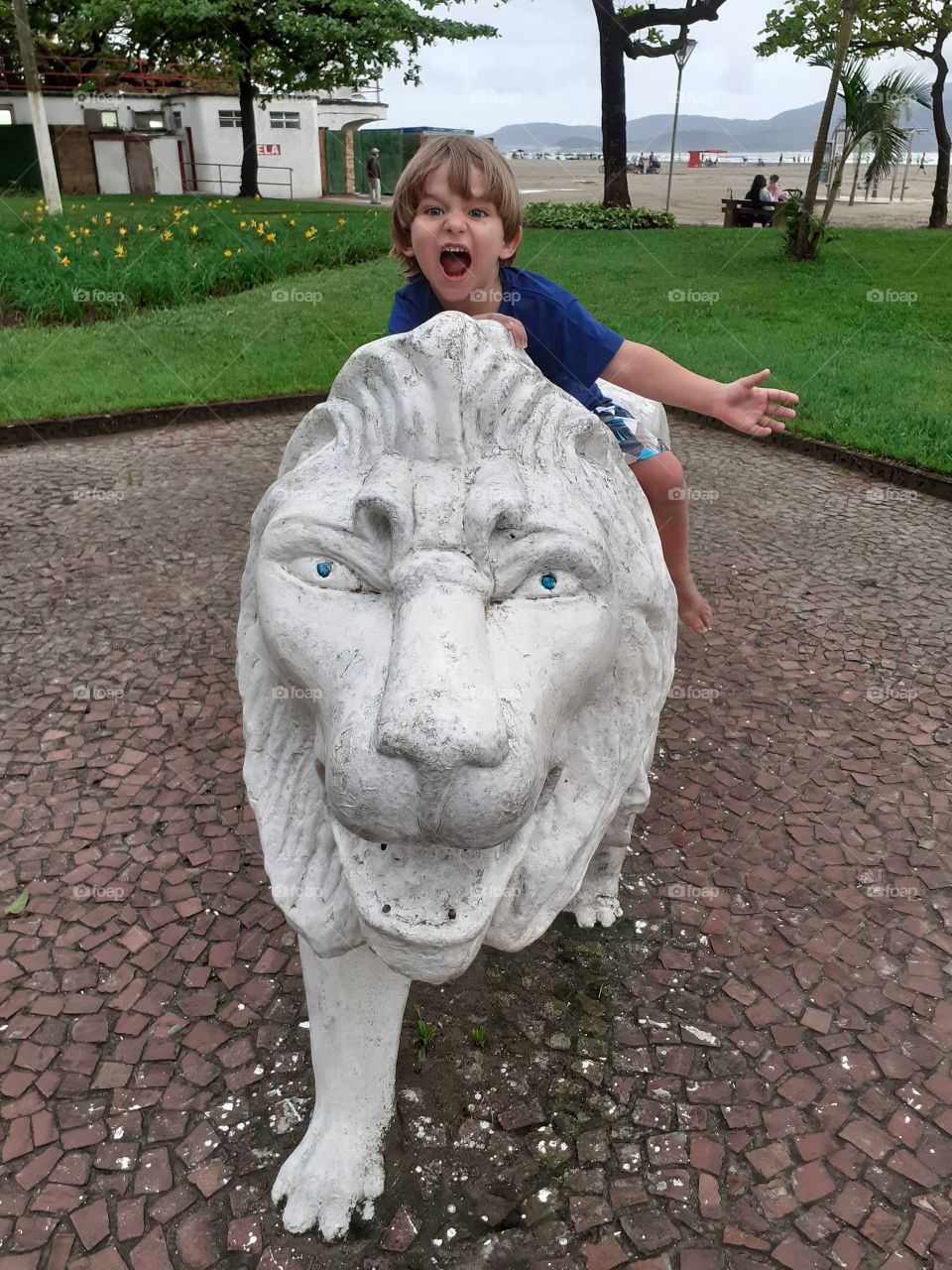 beautiful child on top of a lion in the square in Santos