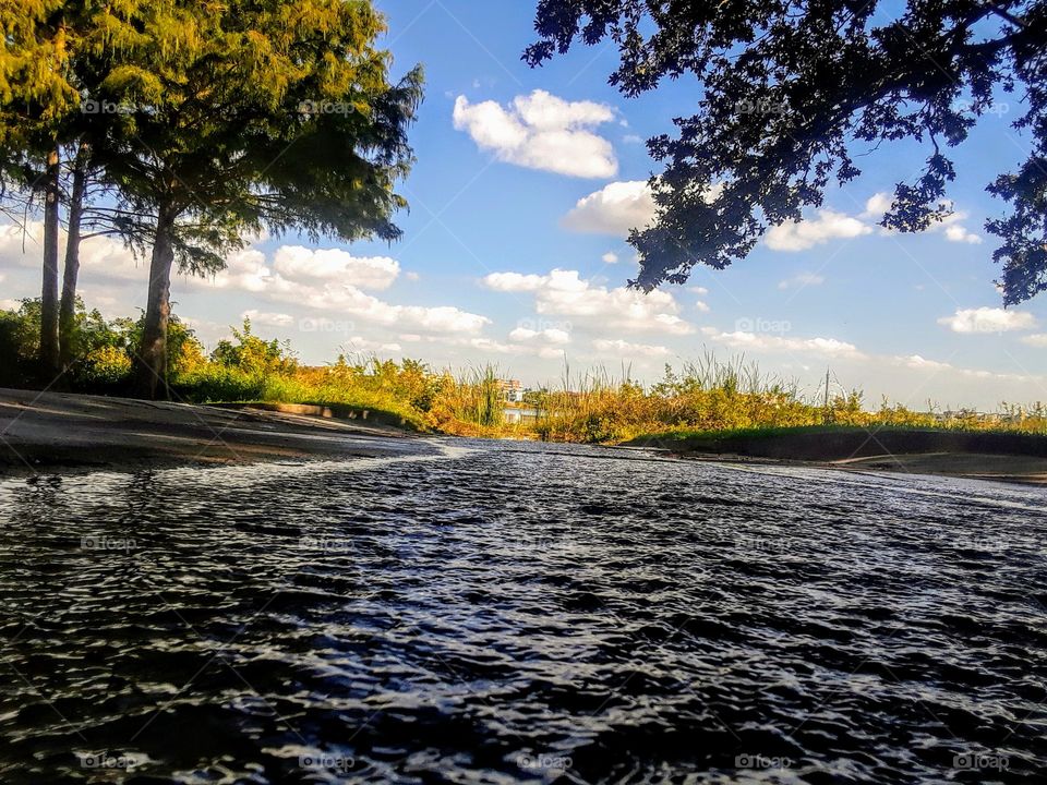 camera closeup of  tiny narrow inlet (approx 2 ft wide, 2 inches in depth) running into lake.. creating riverlike illusion.