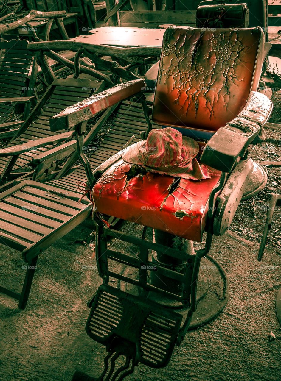 Retro and vintage hairdresser chair with worn and faded red leather.