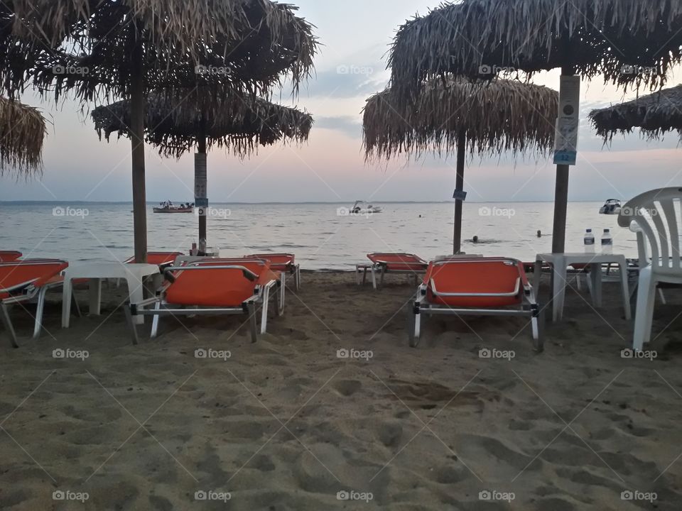 Sunbeds in sunset on the beach