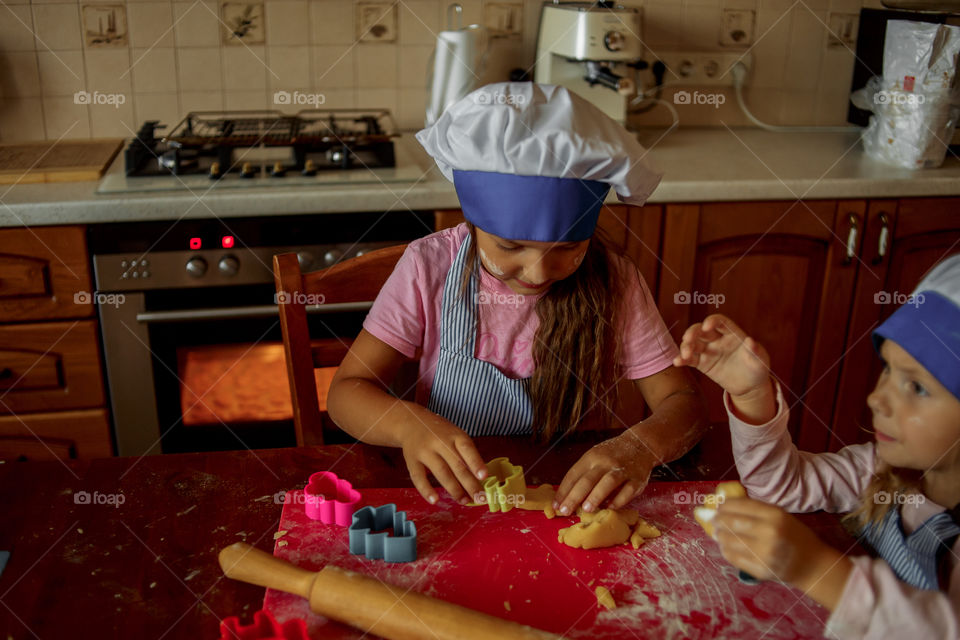 Little sisters cooking the biscuits 