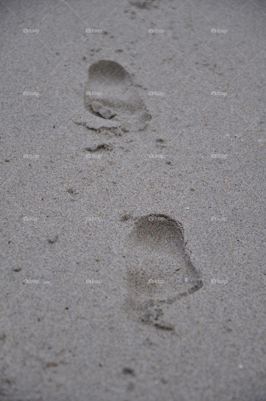Child footsteps in the beach sand