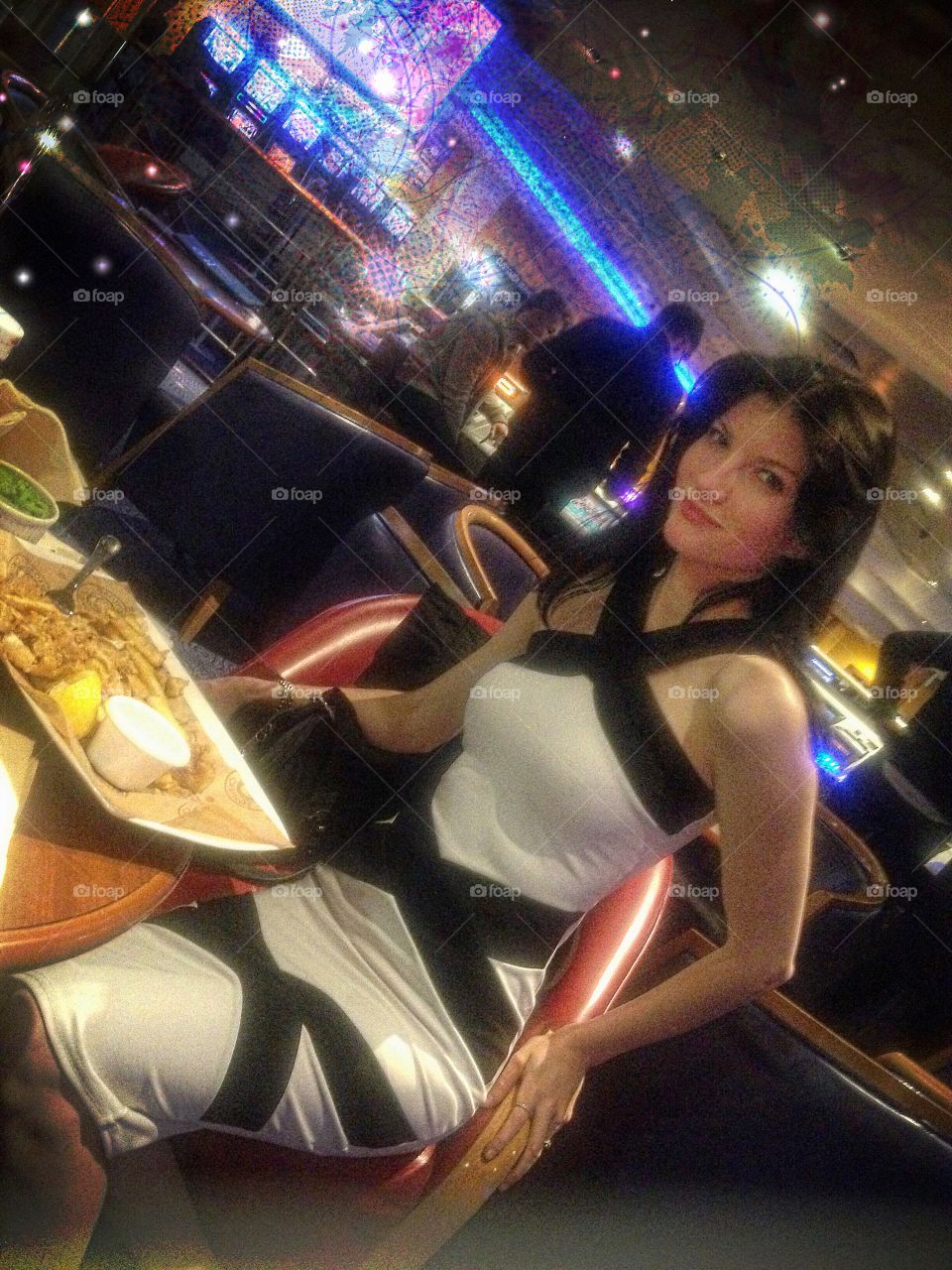 Woman eating at casino with sexy dress sitting at restaurant table 
