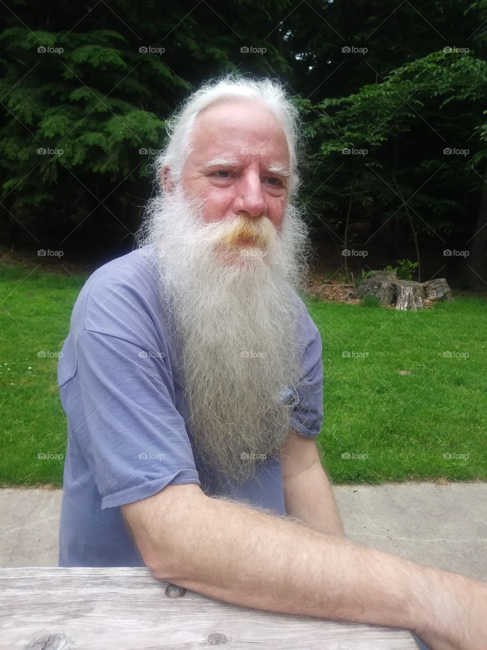 Bearded man sitting outside in a park setting
