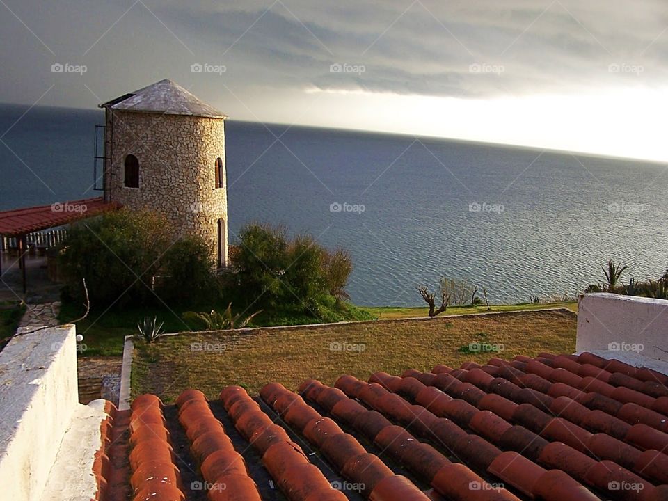 Storm approaching a tower, view from my window of the Aegean Sea in Greece