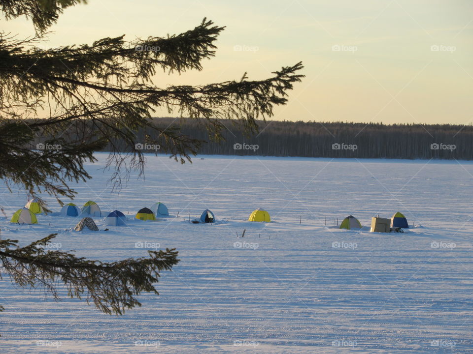 tents of fishermen on the ice in the pond in the Urals in Russia