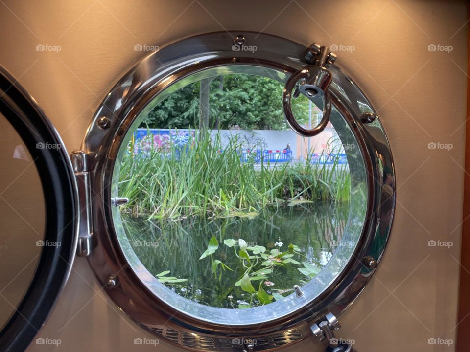 View Through Port Hole Of A Dining Boat On Grand Canal, Dublin City, Ireland