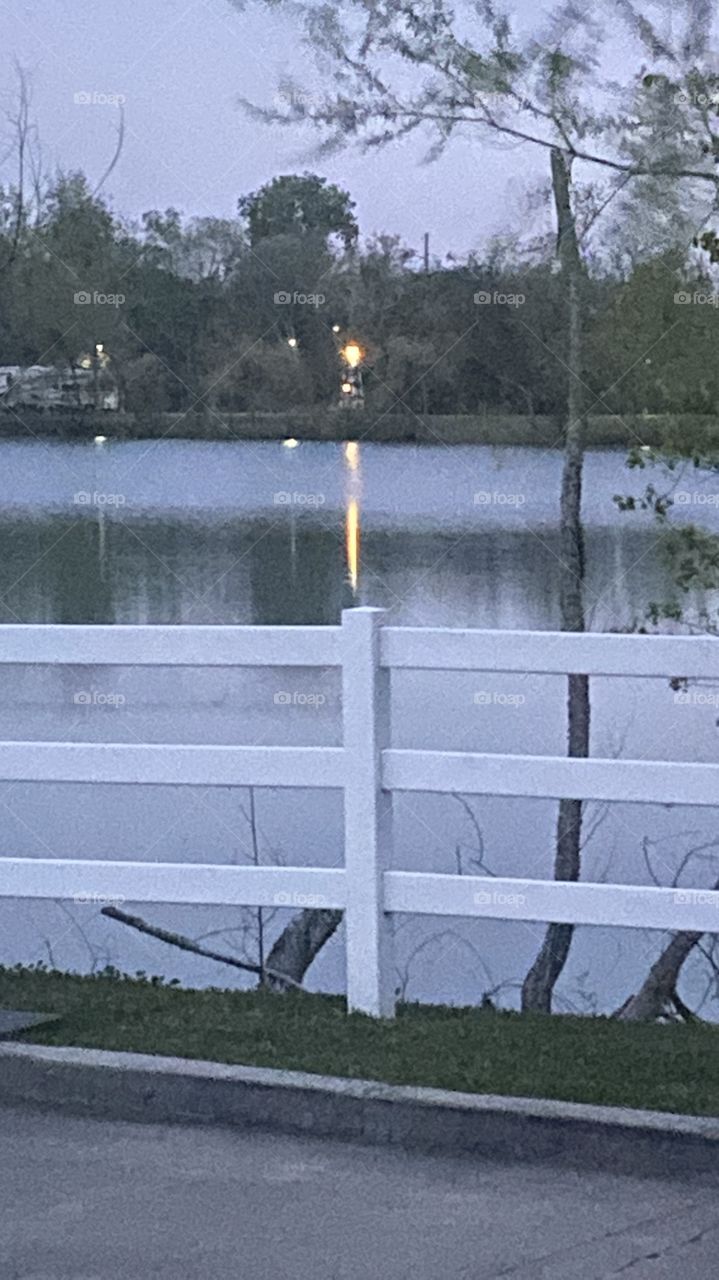 Good Sunday Morning half way to daybreak and I wanted to take a pick of Lighthouse across the lake with the long light beam on the top of Lake Waters. What beautiful early morning pic.