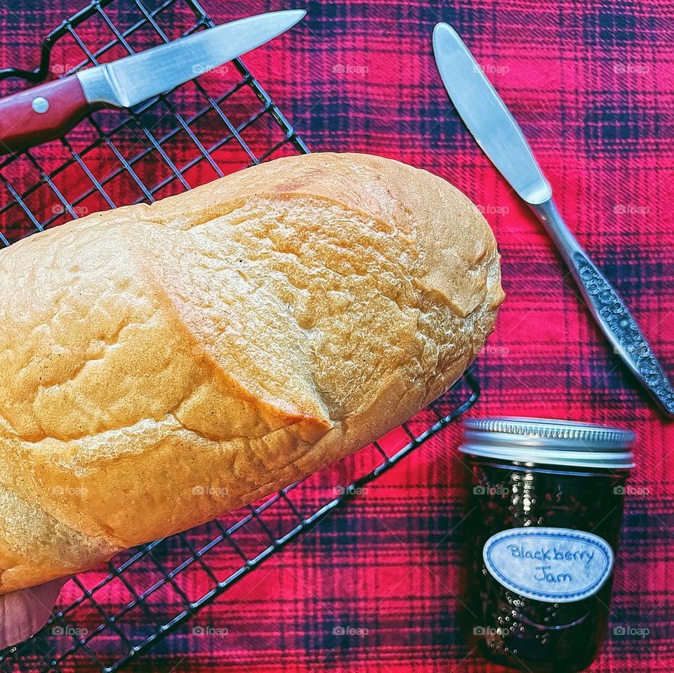 Closeup of homemade bread loaf, woman holding homemade bread, getting ready to eat homemade bread, making bread at home, homemade jam and bread, eating at home, baking and canning at home 