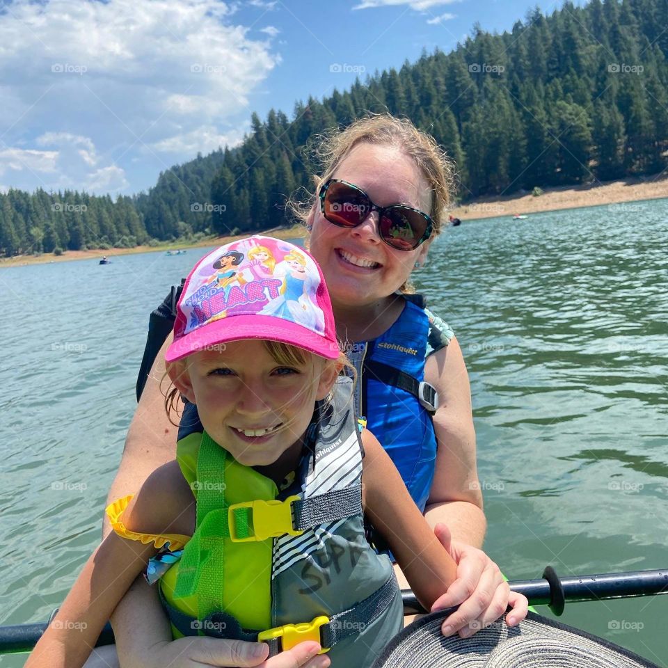 Mother daughter kayaking on beautiful blue lake together