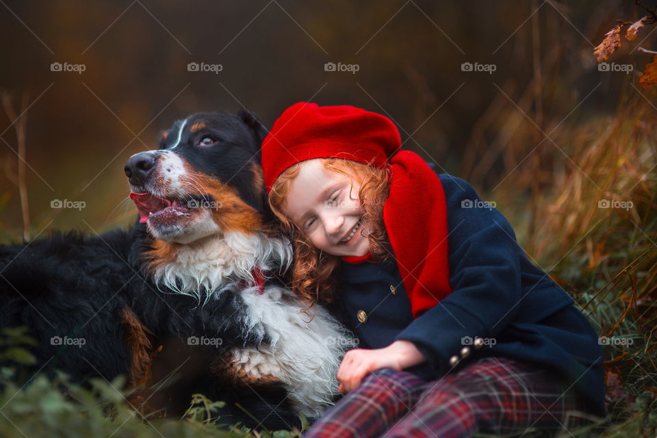 Little girl with Bern shepherd dogs in autumn park 