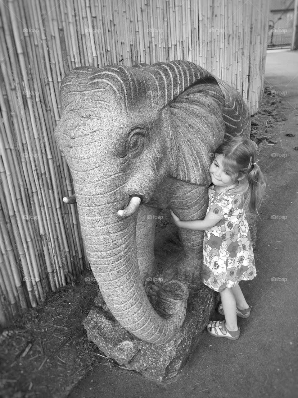Girl standing with elephant sculpture