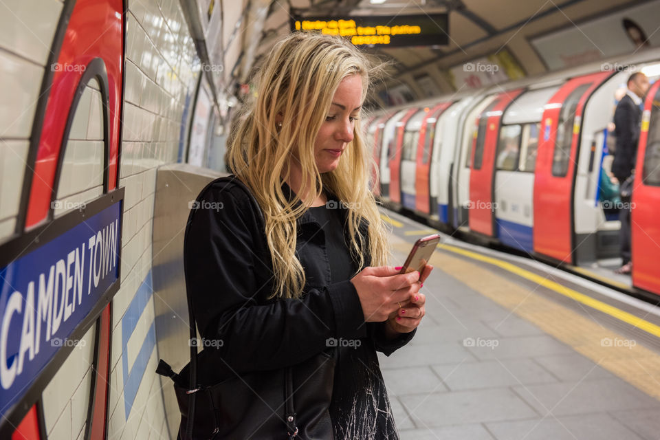 Woman swedish tourist in London 30 years plus looking on ger phone in London tube.