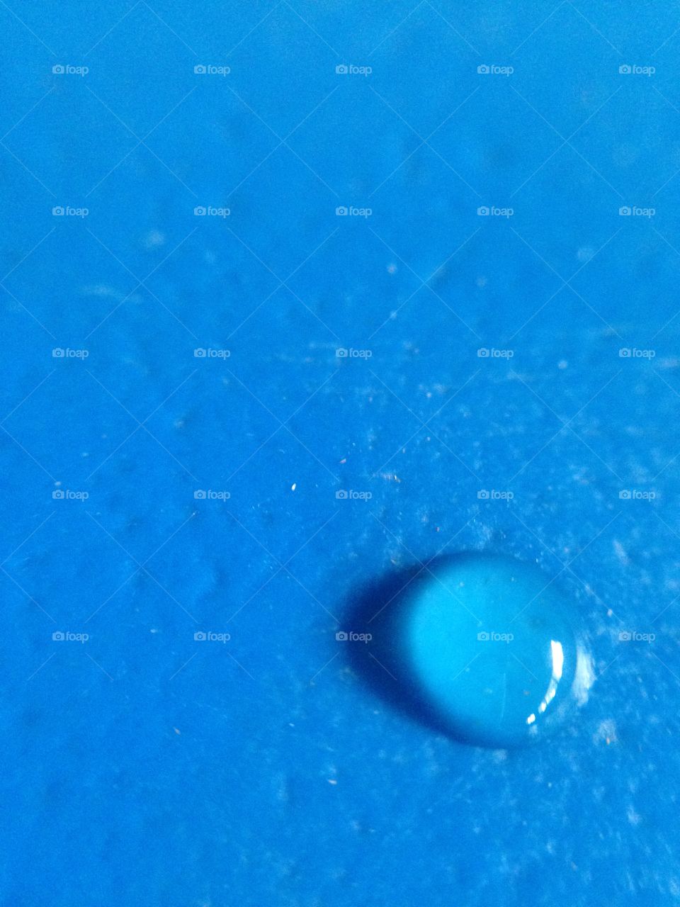 One drop of water on blue plastic