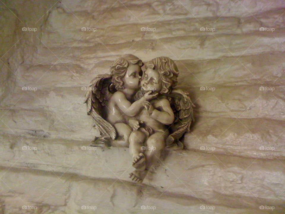 A sculpture of two Little angles kiss