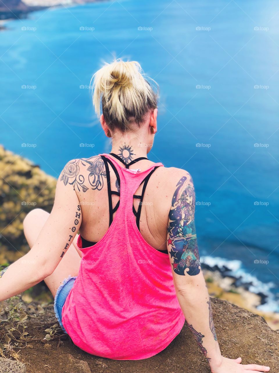 Tattoos and up close shot of overlooking the water in western Oahu 