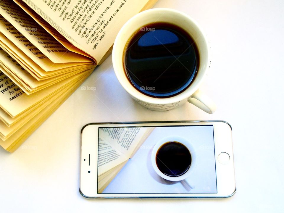 Coffee on the table with book and mobile phone set on coffee photo