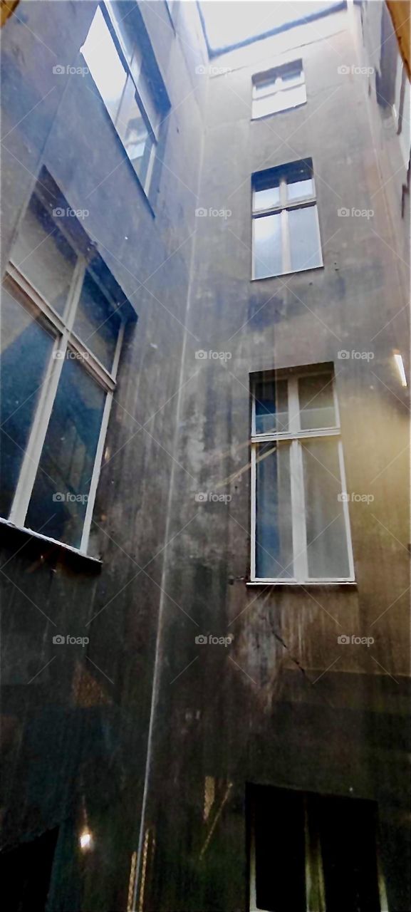 This is a typical facade of an old fashioned building in „Berlin“, „Germany“ expanding over several others of the same street number and several backyards in between as seen looking out onto the backyard. 2023. Hypnotic Productions