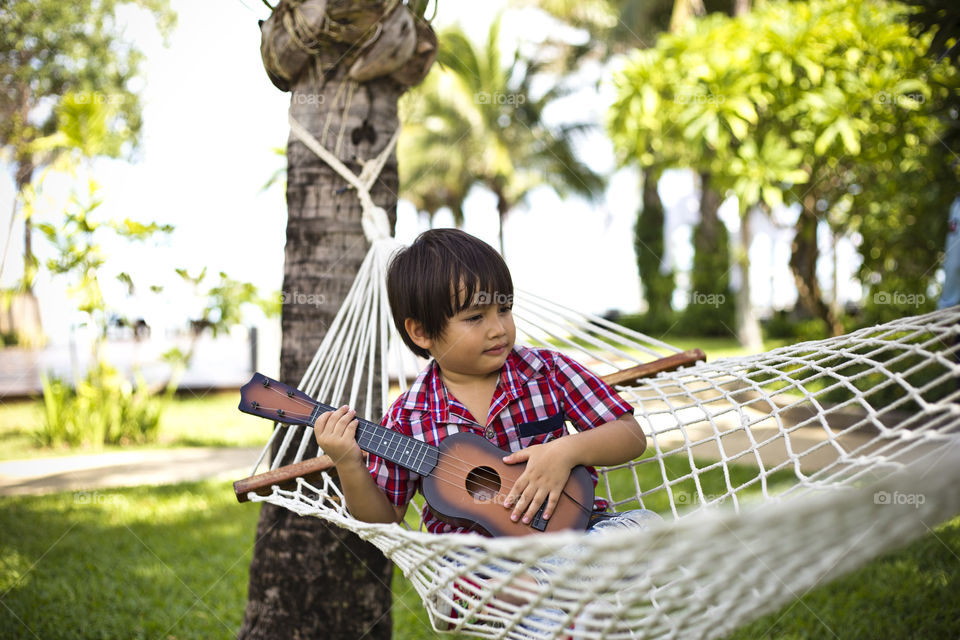 Guitar boy on a hammock. listen to the melody