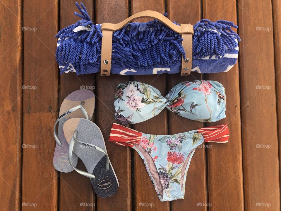 Summer vibes in a pool towel, a bikini and a slipper in blue tone