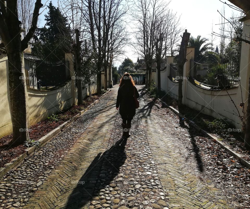 Shoulder girl walks along the avenue