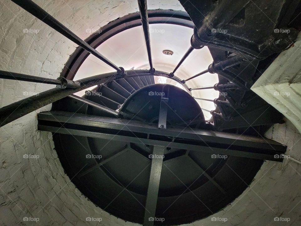 View looking up a black steel spiral staircase