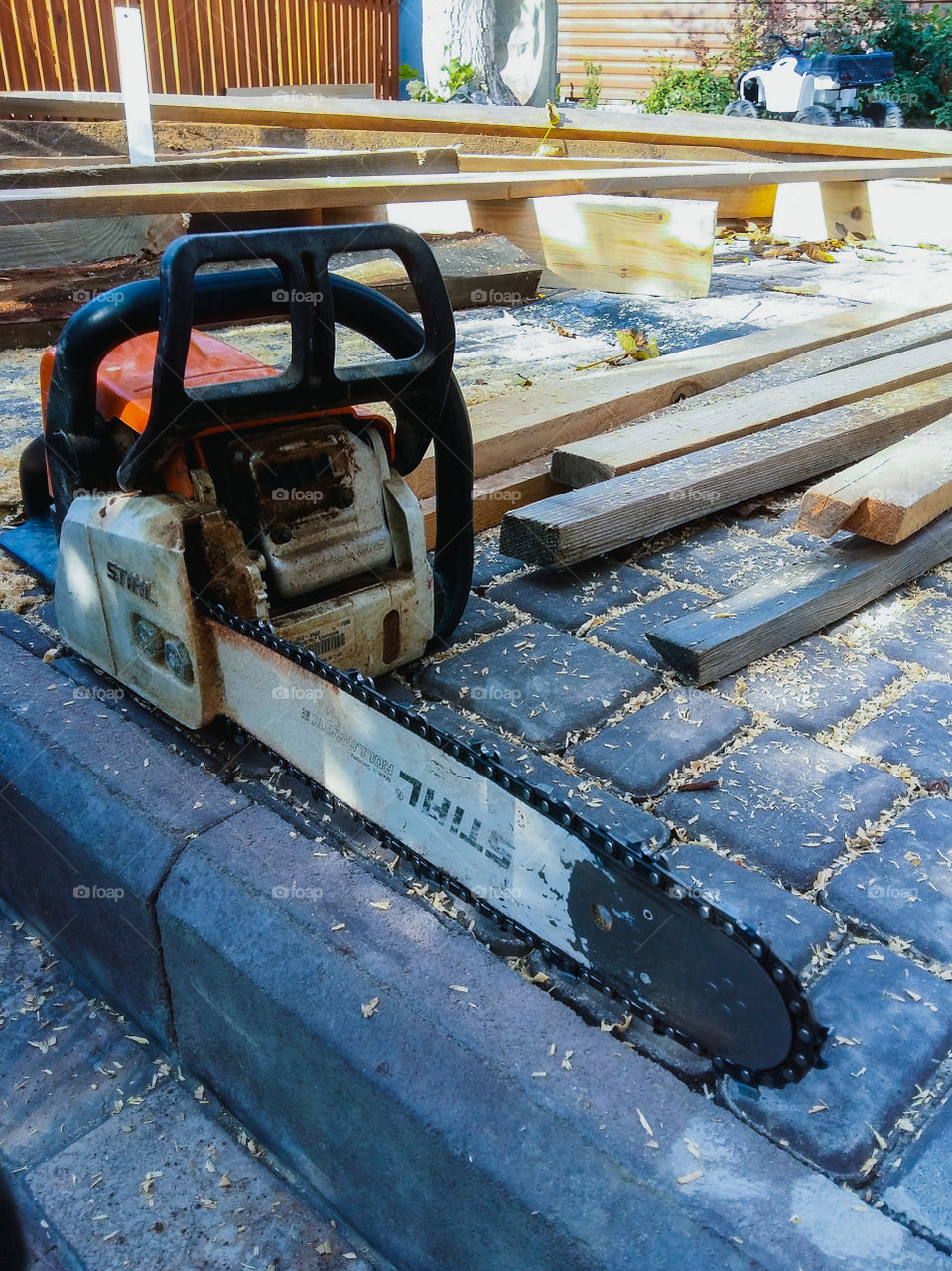 chainsaw on the background of wooden boards and sawdust